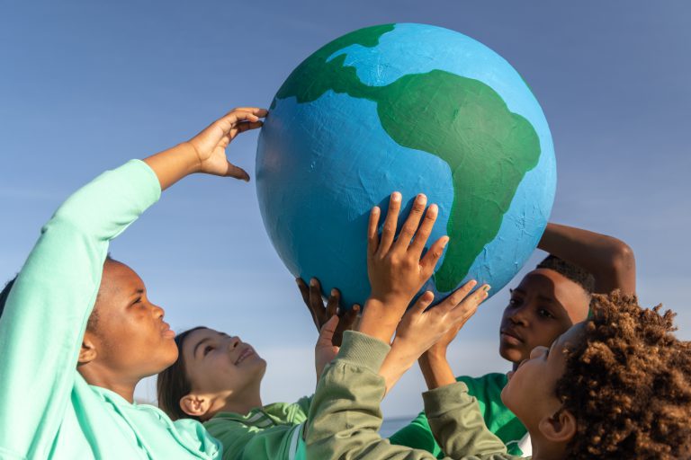 Children lifting a globe towards the sky